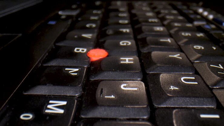 Macro slow travel over an empty laptop keyboard in a dark room