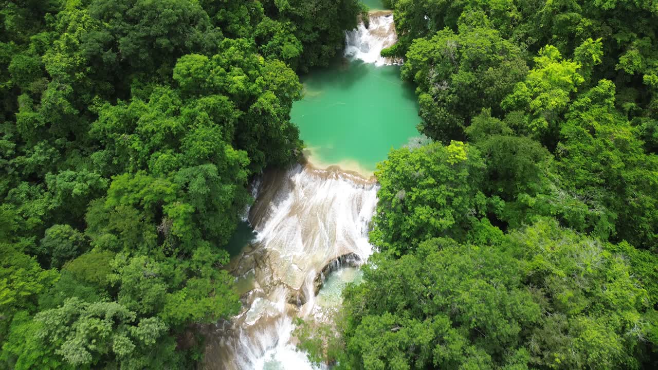Aerial pullback of Roberto Barrios waterfalls cascading into turquoise pools within the forest smooth water, no people