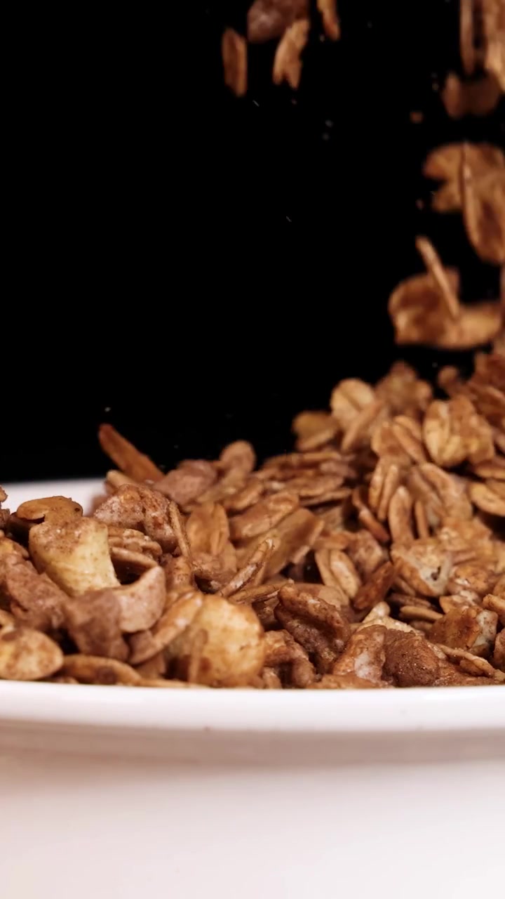 Mano che afferra e versa granola croccante in una ciotola