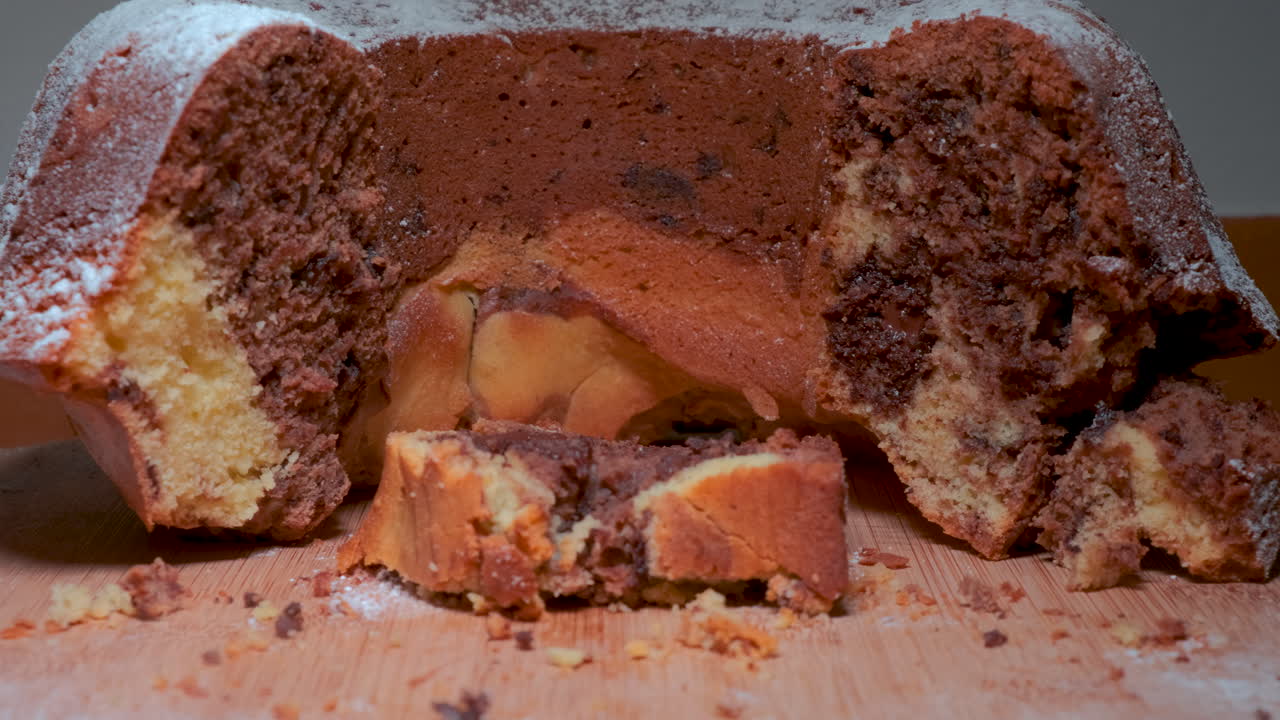 나무 접시에 있는 전통 대리석 케이크, 원암은 케이크를 자르고, 칼로 케이크를 자른다