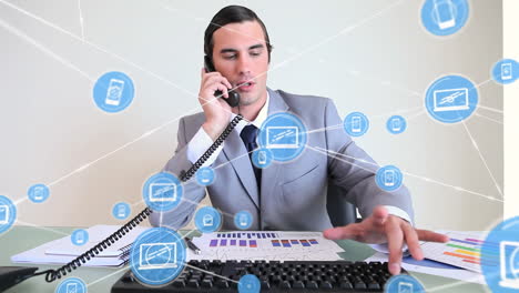 animación de una red de iconos digitales sobre un hombre de negocios caucásico hablando por teléfono y usando una computadora