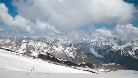 Air-flight-through-mountain-clouds-over-beautiful-snow-capped-peaks-of-mountains-and-glaciers.