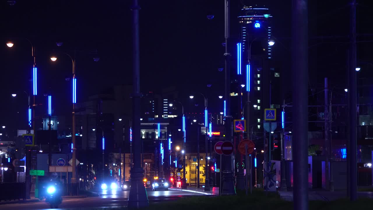 Stadtstraße bei Nacht mit bunten LED-Straßenlaternen