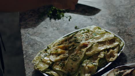 pizza maker cutting parsley in kitchen