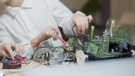 caucasian child measuring electric current in circuit board set