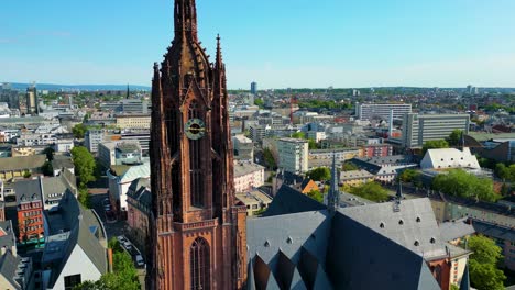 4k aerial drone video of the clock tower of the historic kaiserdom st. bartholomäus church in downtown frankfurt, germany