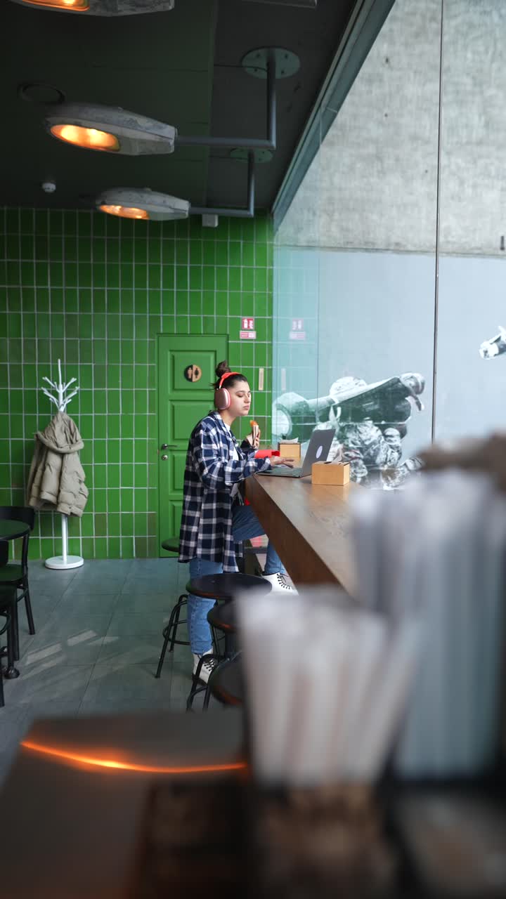 Jovem mulher trabalhando em um café moderno