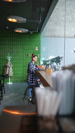 mujer joven trabajando en un café moderno