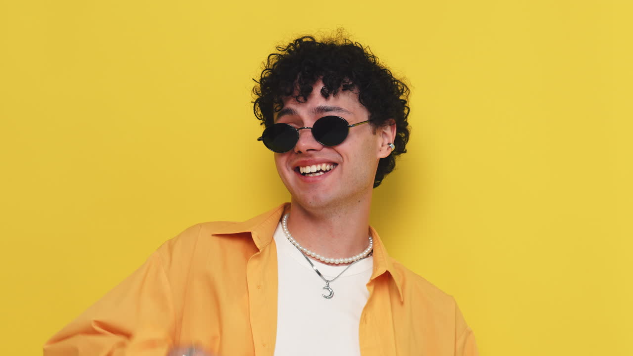 Man wearing stylish sunglasses and a yellow shirt