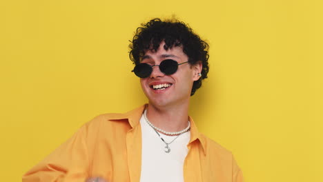 hombre con gafas de sol elegante y una camisa amarilla