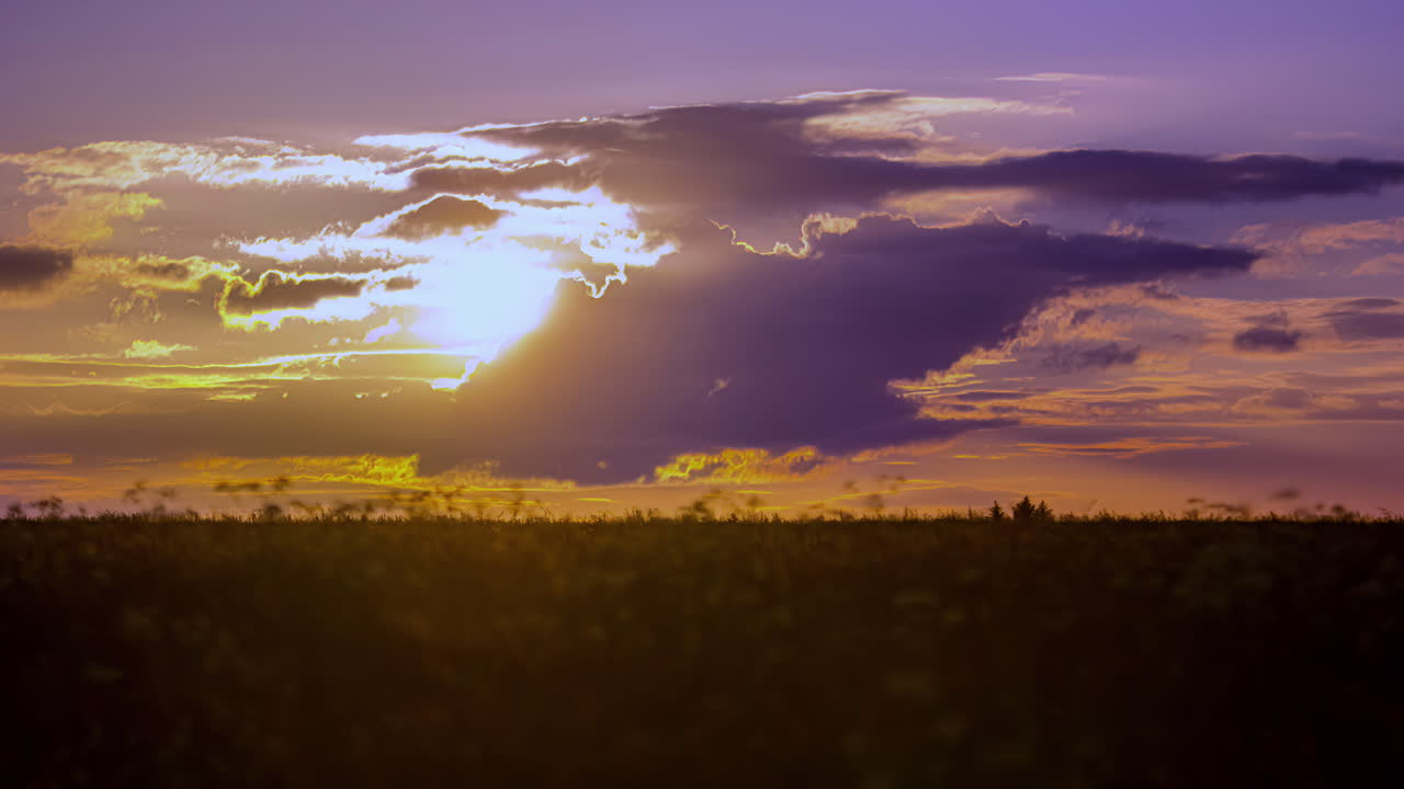 cenário de nuvens douradas ao nascer do sol sobre um campo agrícola - lapso de tempo