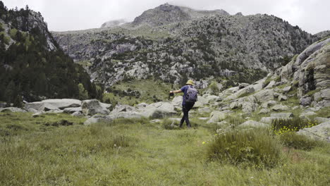 aigüestortes national park catalan pyrenees static shot of young adventure trekker walking alone reaching peak of mountains in pure unpolluted natural spot