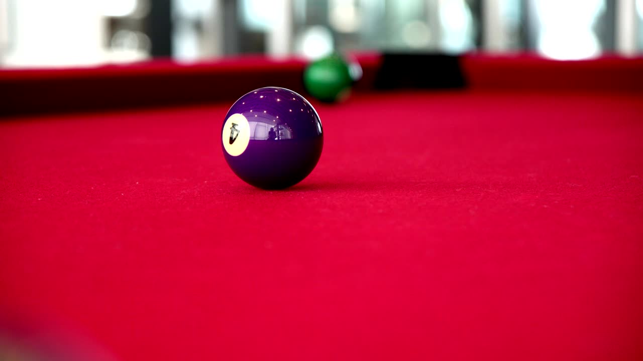 Playing the pool-billiard game on red baize table. This is sports