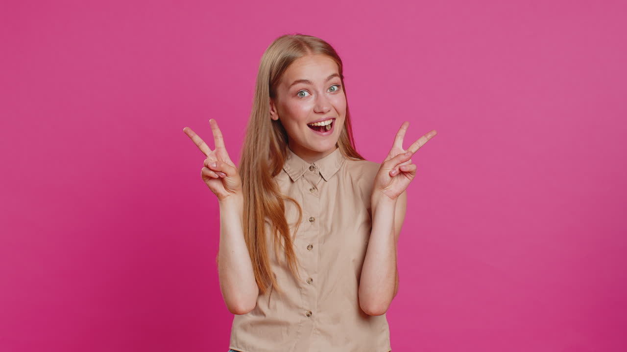 Woman girl showing victory v sign hoping for success and win doing peace gesture with two fingers