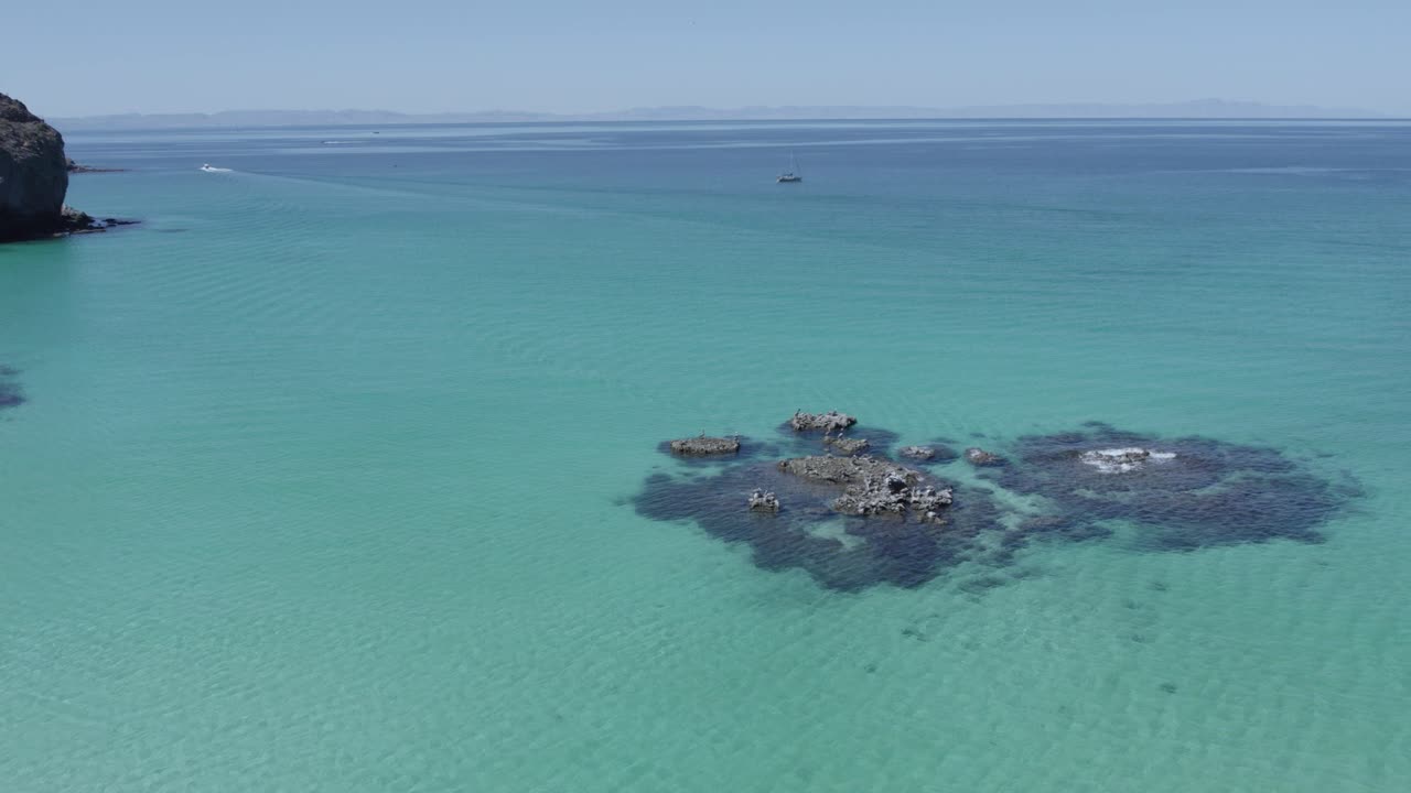Lateral drone view over rocks in middle of the sea in Balandra Beach