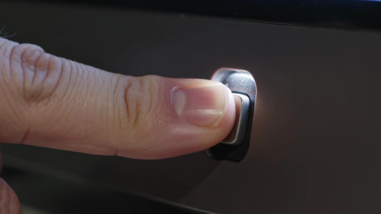 Pressing index finger entering from left, pressing power button on dark glossy panel, powering unit