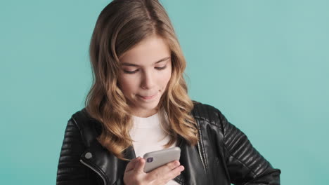 Teenage-Caucasian-girl-in-leather-jacket-using-her-smartphone.