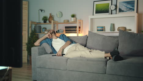man watching tv on couch at night