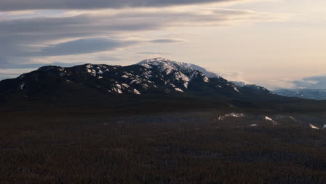 an aerial perspective over whitehorse, yukon, capturing grey mountain, golden horn, and the vast snow-covered terrain bathed in the soft light of sunset.