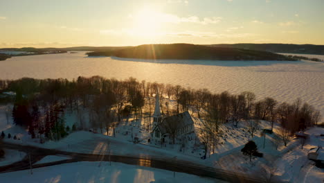 Beautiful-sunset-aerial-view-of-a-scenic,-snow-covered-small-town
