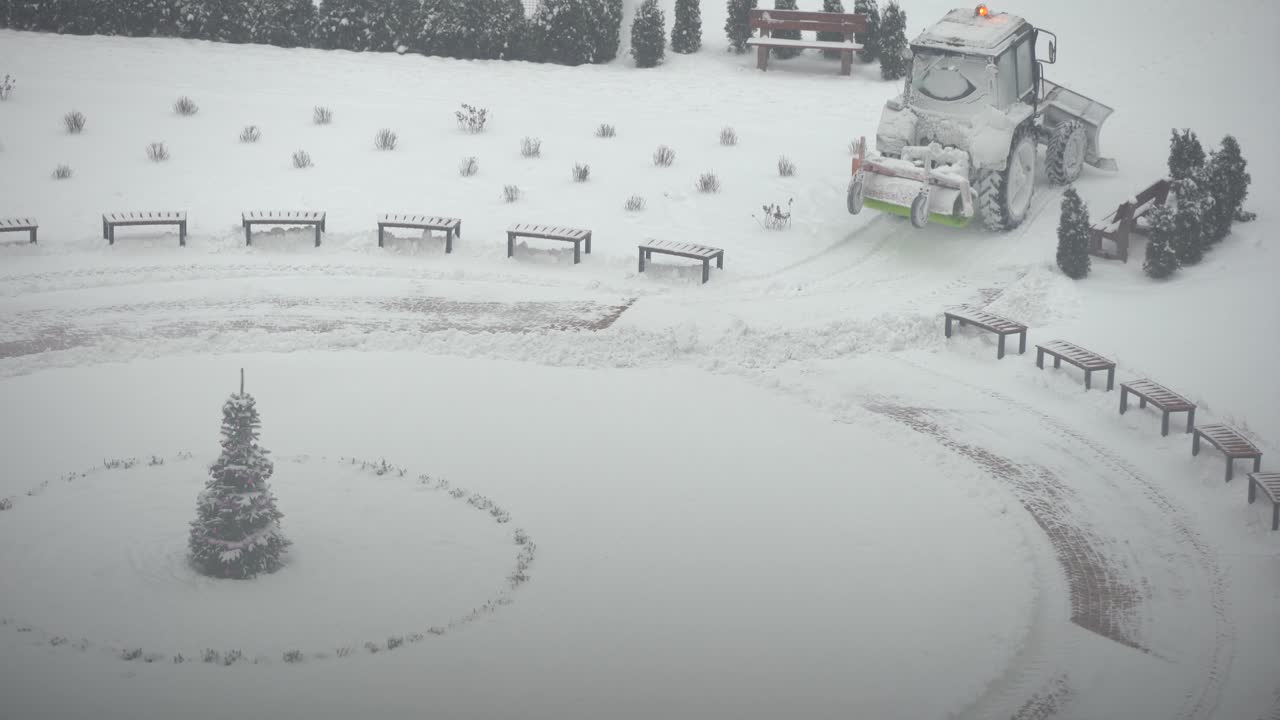 트랙터 굴착기는 도시 마당의 눈을 제거합니다. 공공 시설 업무