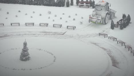 tractor-excavator removes snow in the city yard. work of public utilities