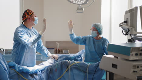 equipo quirúrgico de alto-fiving en la sala de operaciones