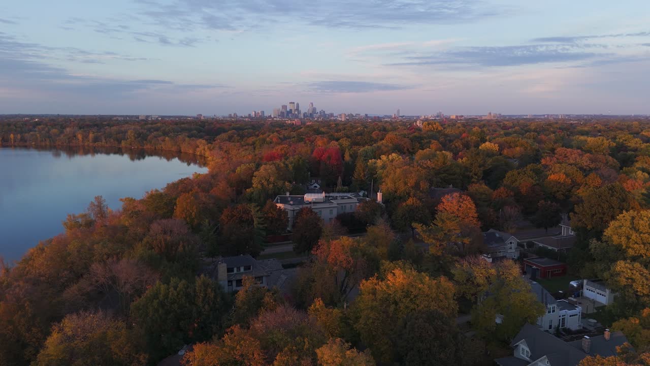 Minneapolis skyline shows over tree canopies with autumn foliage, view from south minneapolis during autumn