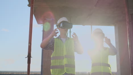 two contemporary crew workers using vr to visualize projects standing in unfinished building on construction site copy space