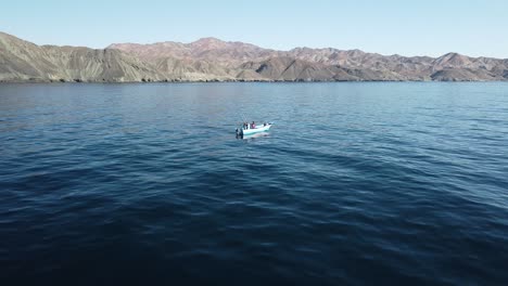 aerial dolly over fishermen prepping lines, rods, and reels with coast background