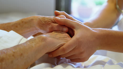 hand of doctor reassuring to senior woman at home 4k