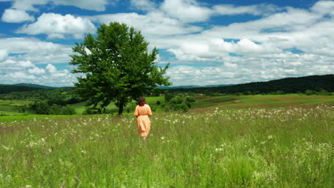 woman walking through open meadow in lika, croatia