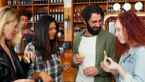 amigos tomando tequila en el mostrador en el bar 4k