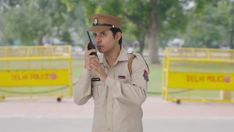 indian police officer giving instructions on walkie talkie