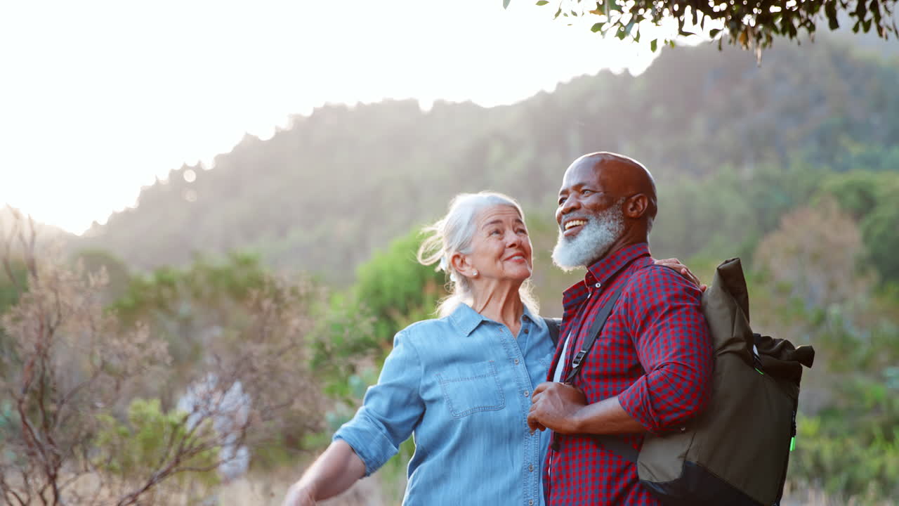 Multi Cultural Group Of Senior Friends Enjoying Hiking Through Countryside Together