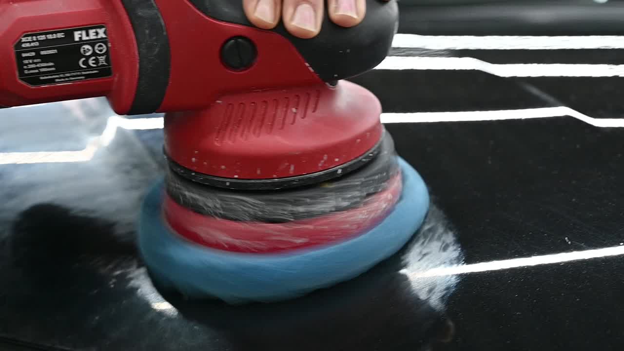 equipo industrial puliendo el capó negro del vehículo, primer plano