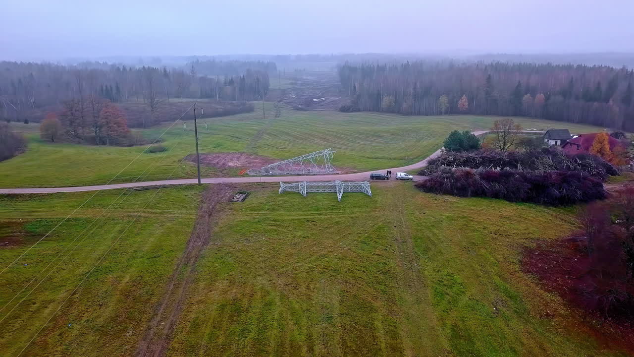흐린 날 농촌 지역에 새로운 송전탑을 설치하는 노동자에게 비행을 향한 공중