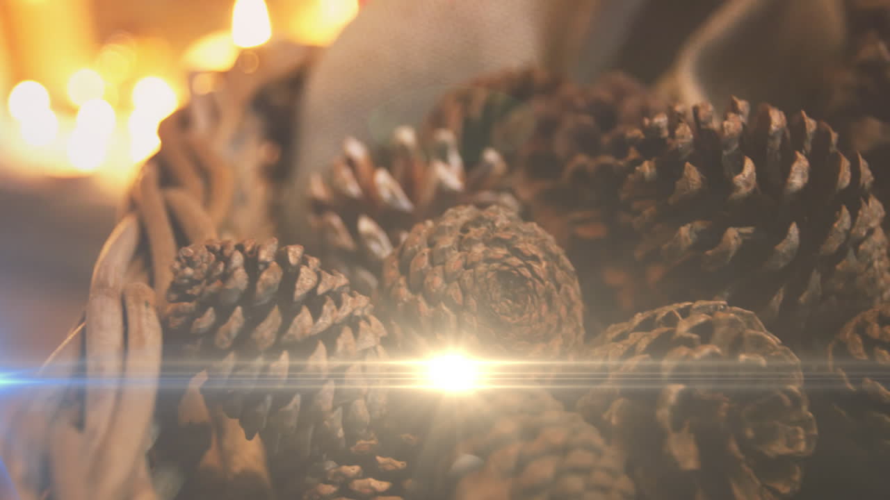 композиция света над рождественскими украшениями с сосновыми шишками и свечами