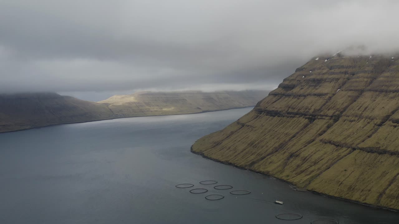 Aerial view of dark clouds on Bor&eth;oy With view to Kunoy and Kalsoy on Faroe Islands