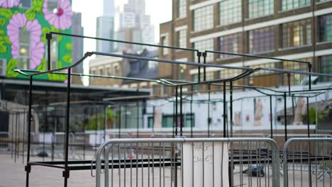 Empty-and-closed-outdoor-market-during-Covid-19-Coronavirus-pandemic,-no-people-during-lockdown,-London-city-skyline-in-the-background-with-high-skyscrapers