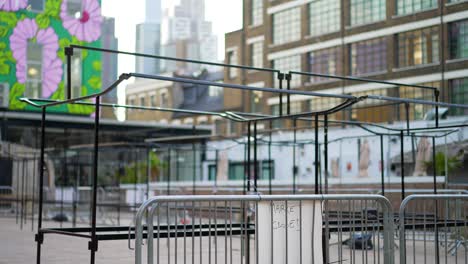 empty and closed outdoor market during covid-19 coronavirus pandemic, no people during lockdown, london city skyline in the background with high skyscrapers