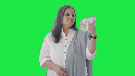 Confident-Indian-senior-businesswoman-using-money-as-fan-Green-screen