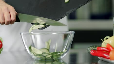 verduras frescas en el restaurante de la cocina. pepino en rodajas en cámara lenta.