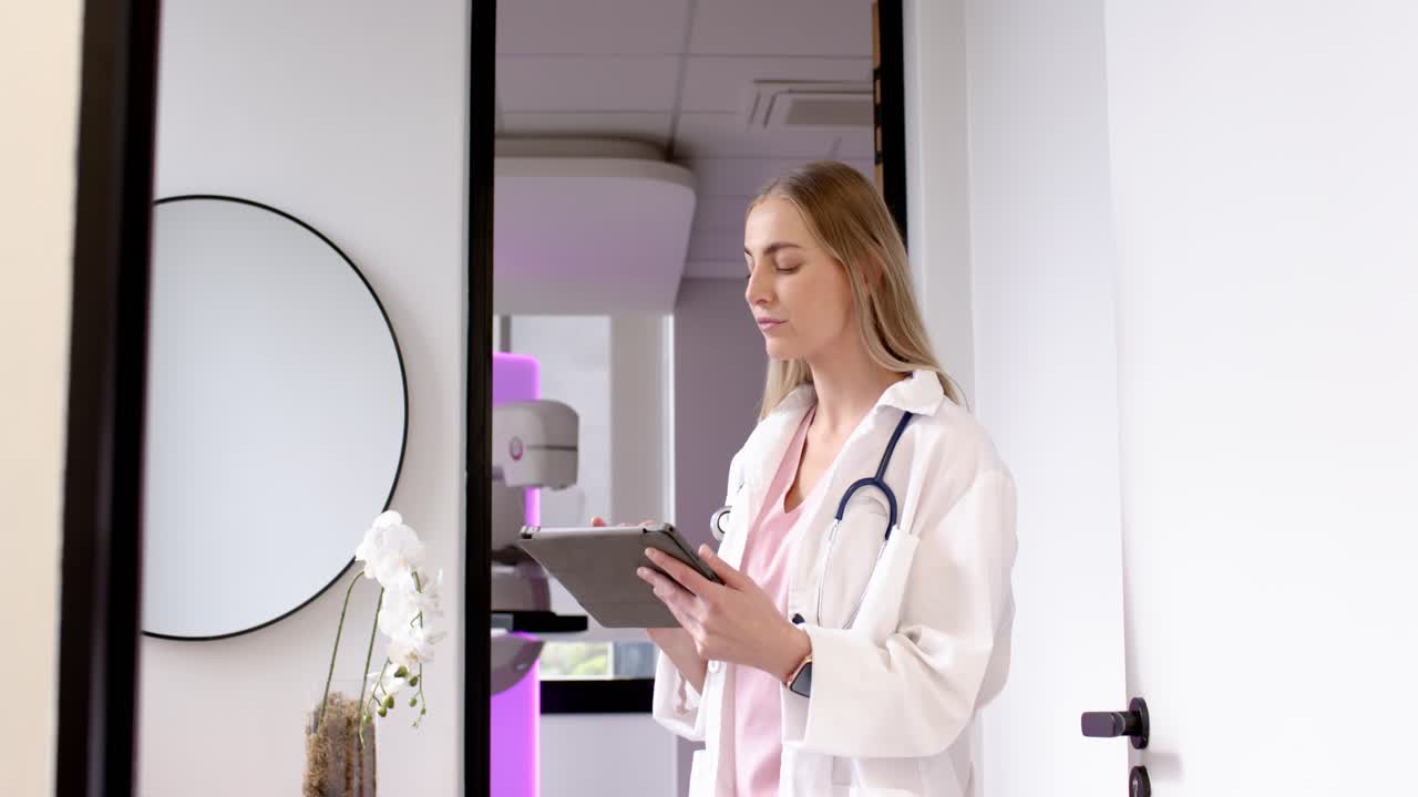 Dottoressa in camice da laboratorio, con stetoscopio sulla soglia, che consulta un tablet e verifica uno scanner illuminato di viola