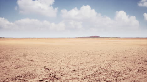 dry, cracked desert landscape under a partly cloudy sky