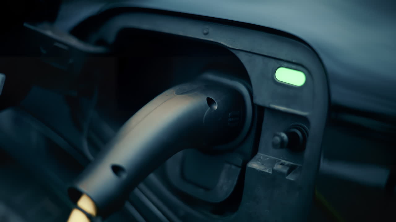 Close up of an electric car being charged, with cable plugged into port