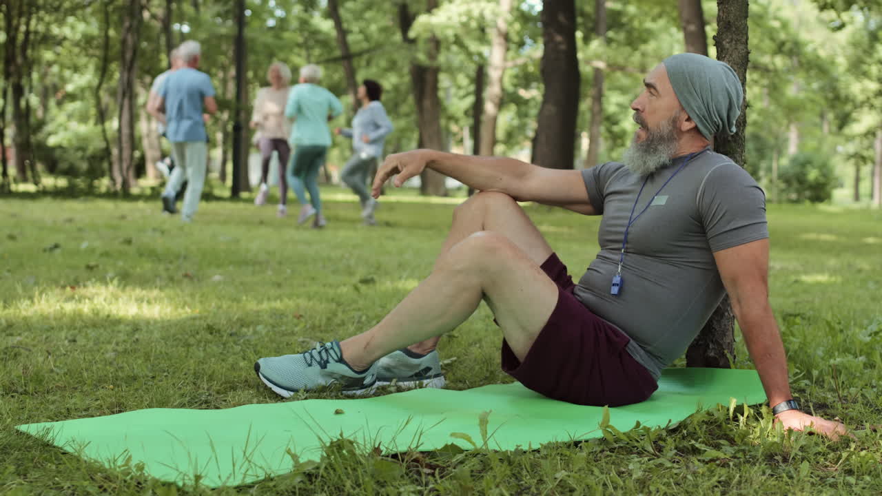Senior man relaxing after exercise in a park