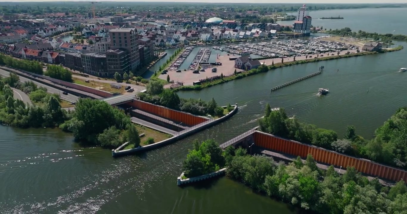 Drone kredser om den ikoniske bådformede Veluwemeer-akvædukt, fanger både, der krydser ovenover, biler, der kører nedenunder, og afslører Harderwijk by og dens havn på en lys sommerdag