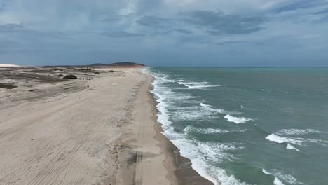 scenic view of waves crashing on jericoacoara’s white sand beach along the coastline