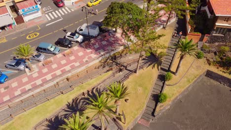 Sunny-La-Arena-Beach-in-Tenerife,-with-a-path-leading-to-beach,-aerial